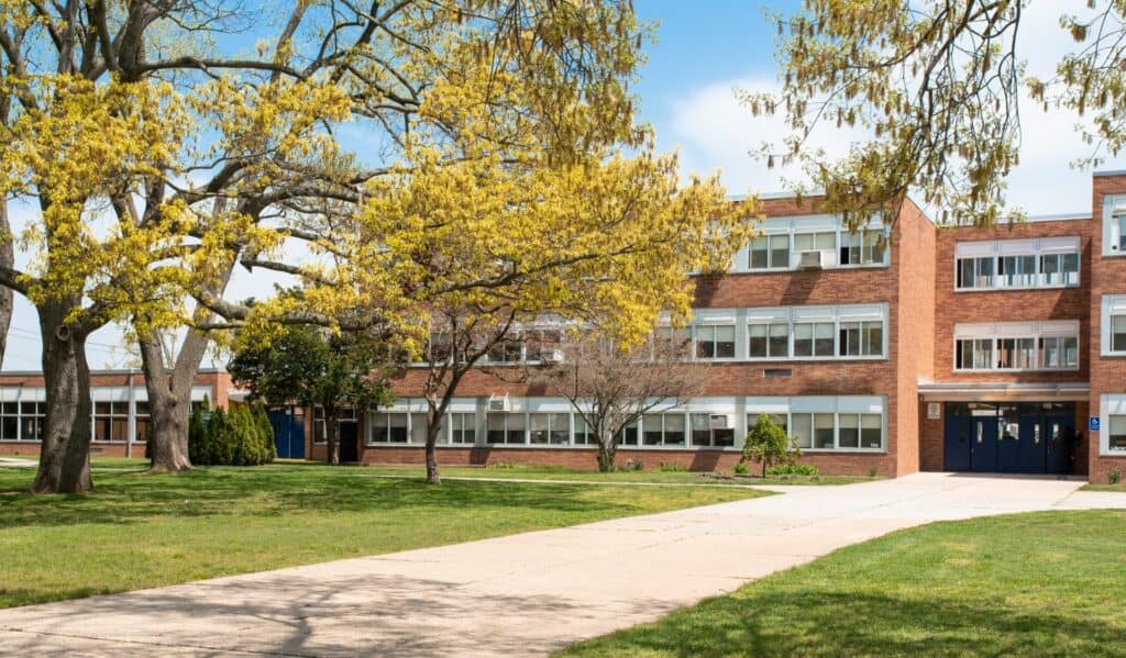 École avec arbres et pelouse verte.